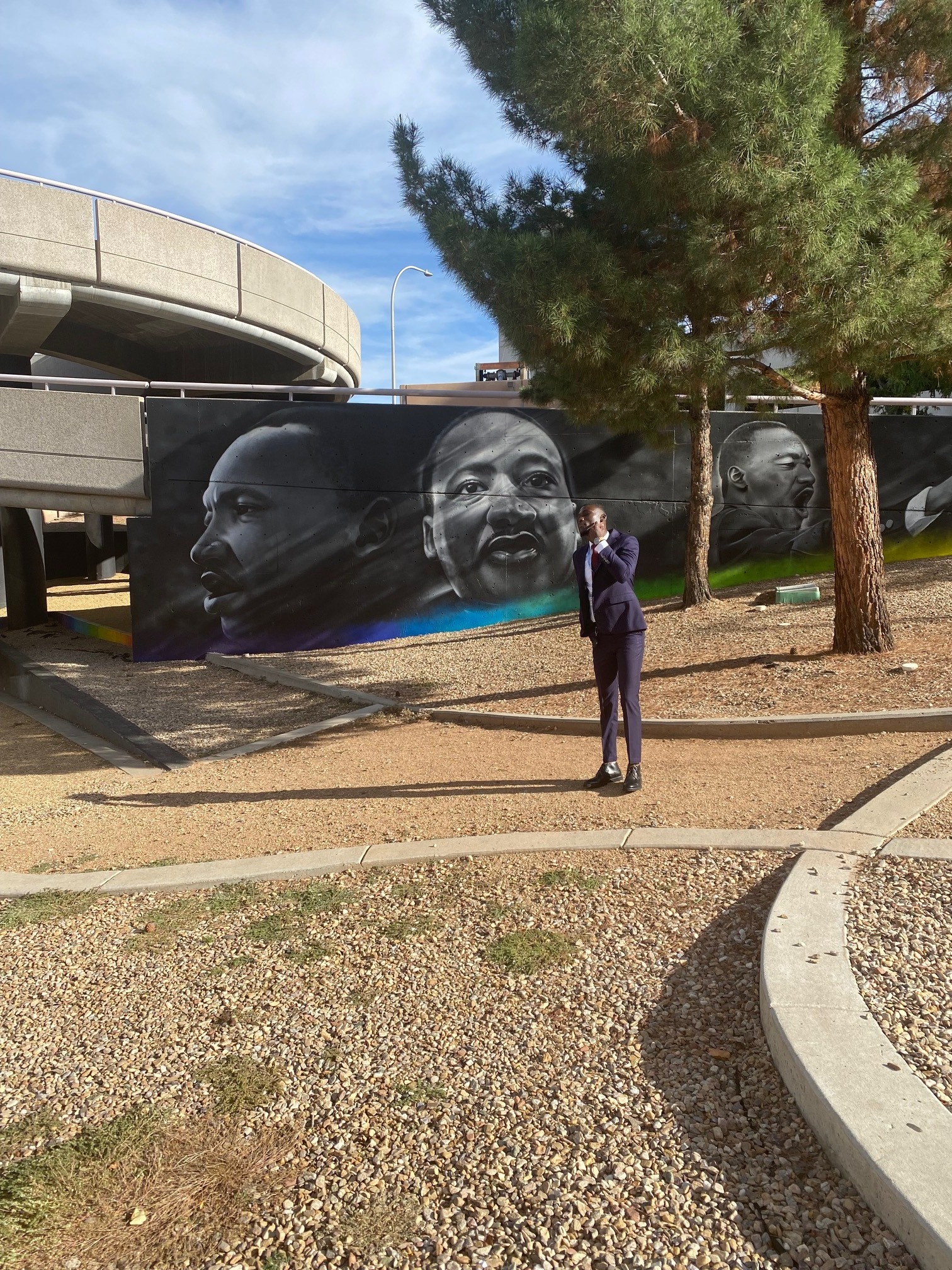 Winfred Arthur-Arhin near a Sankofa and Nkyinkyim installation